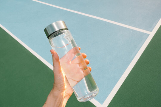 Hand Holding Water Bottle Outdoor Tennis Court