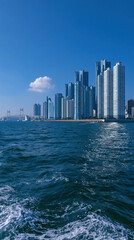 Obraz premium Modern city skyline with skyscrapers viewed from ocean water