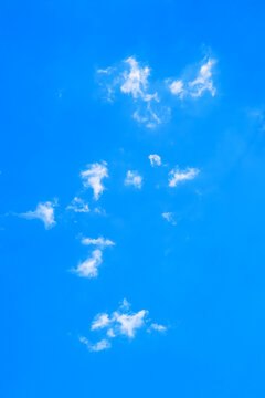 small white clouds in a bright blue sky