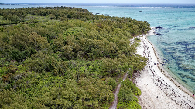 Aerial high angle shot of the sandbar beach, turquoise lagoon channel, and anchored boats at Ile aux Cerfs, Mauritius