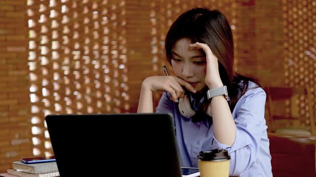 Young Asian Businesswoman Working Remotely with Laptop and Smartphone in Traditional Wooden Cafe, Digital Nomad Lifestyle