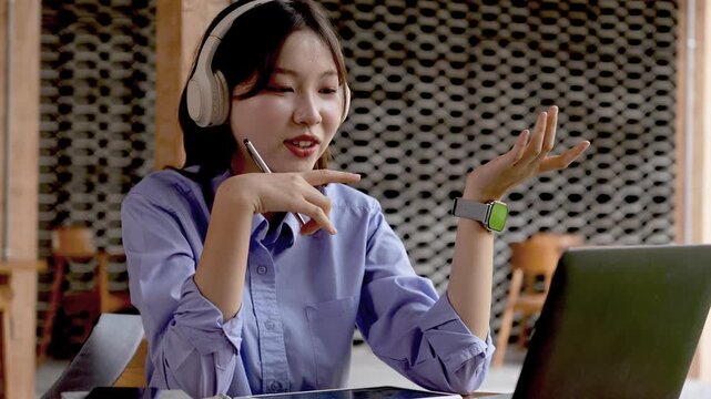 Young Asian Businesswoman Working Remotely with Laptop and Smartphone in Traditional Wooden Cafe, Digital Nomad Lifestyle