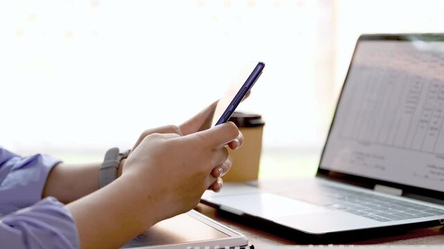 Young Asian Businesswoman Working Remotely with Laptop and Smartphone in Traditional Wooden Cafe, Digital Nomad Lifestyle