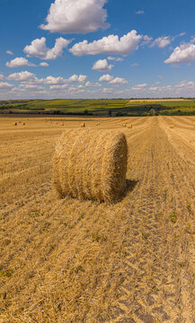 Straw bales on harvested wheat field aerial drone view, agricultural cereal crop and summer harvest concept