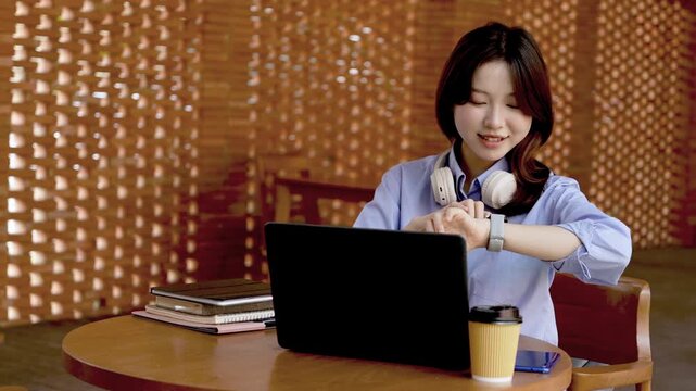 Young Asian Businesswoman Working Remotely with Laptop and Smartphone in Traditional Wooden Cafe, Digital Nomad Lifestyle