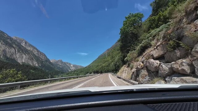 Driving through the Pyrenees mountains from a car's dashboard view