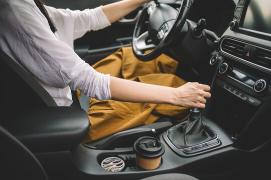 Cropped shot of woman drinking takeaway coffee while driving a car