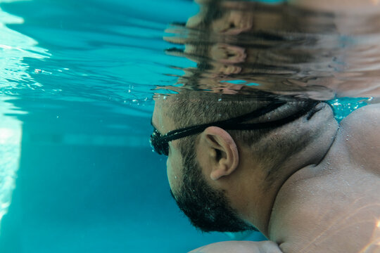 Man Swimming Underwater in a pool
