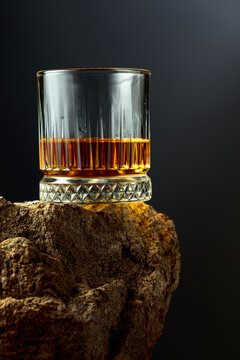 Glass of whiskey on a rough granite.