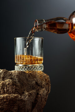 Whiskey is poured from a bottle into a glass.