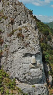 Aerial view of stone carved statue portrait of ancient dacian king Decebal. Sculpture near Danube River, Romania. Vertical video 4k