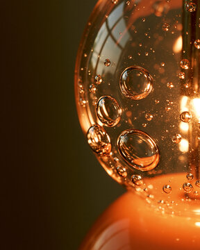 Glowing vintage glass lightbulb with orange bubbles and reflections in modern cozy interior decor close-up