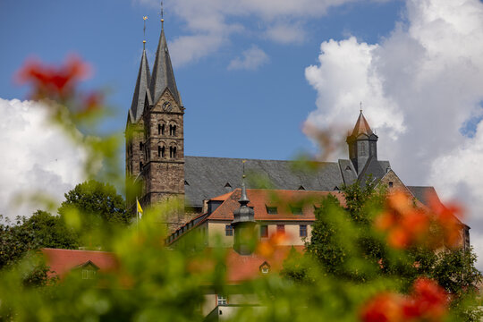 View, framed by flowers, of the Roman-Catholic St Peter's Church (also Fritzlarer Dom) in the medieval old town of Fritzlar, Hesse, Germany