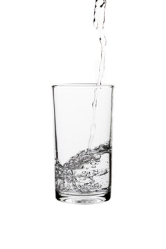 Pouring fresh drinking water into a clear glass isolated on a white background. Hydration, purity, refreshment, and healthy lifestyle concept.