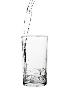 Fresh water pouring into a clear drinking glass isolated on a white background.