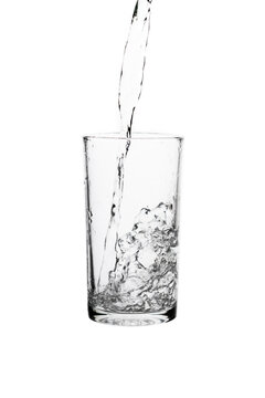 Pouring fresh drinking water into a clear glass isolated on a white background. Hydration, purity, refreshment, and healthy lifestyle concept.