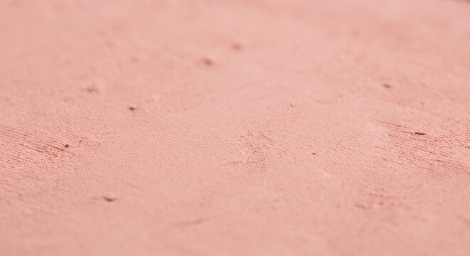 Close up of fine pressed cosmetic powder texture with soft velvety matte finish in dusty peach pink color