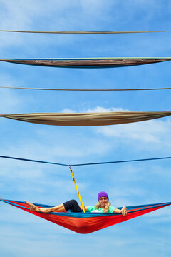 Young woman relaxing in hammock high above ground. A unique high-altitude attraction in Indonesia offering thrilling experiences and panoramic tropical forest views for adventure. Travel on vacation.