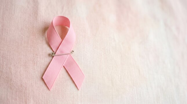 Pink bow made of textured fabric, symbolizing awareness and support for the fight against breast cancer.