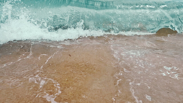 Fotograf&iacute;a art&iacute;stica cenital de olas suaves dibujando espuma sobre la arena de la orilla.
