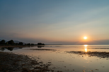 Obraz premium A serene golden sunset casting glowing reflections over the calm, shallow waters of Lake Constance as seen from the scenic Rohrspitz shore in Vorarlberg, Austria.