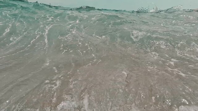 V&iacute;deo art&iacute;stico de una ola rompiendo sobre la c&aacute;mara, con espuma, turbulencia y textura marina.