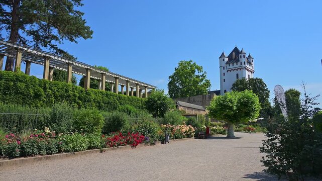 Ein Burgturm mit befestigten Mauern und gepflegtem Garten unter einem klaren blauen Himmel, Kurf&uuml;rstliche Burg Eltville, Eltville am Rhein, Rheingau, Hessen, Deutschland