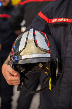 French firefighter holding a protective helmet during an emergency response