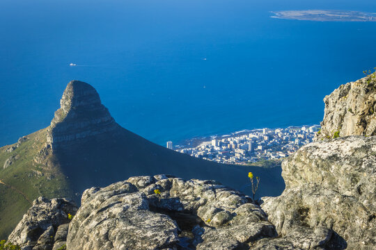 Aerial view of Lion's Head peak, the Camps Bay coastline and Robben Island from the summit of Table Mountain at golden hour, Cape Town, South Africa