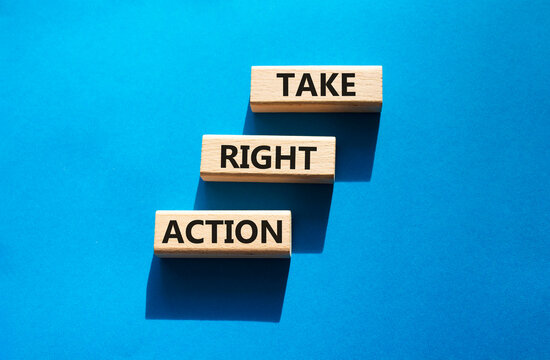Take right action symbol. Concept words take right action on wooden blocks arranged as steps. Decision making and productivity concept. Blue background. Copy space.