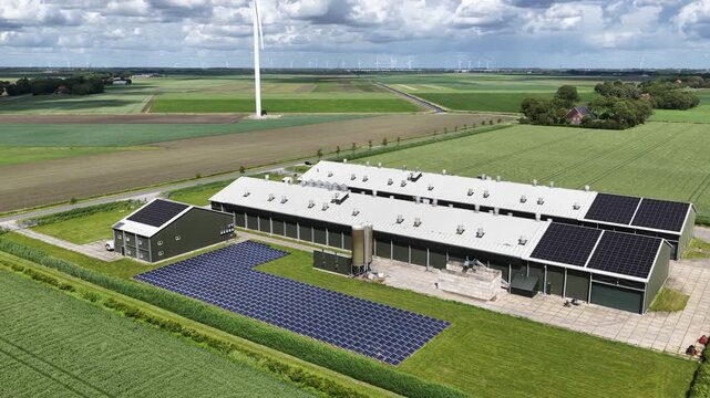 Aerial view of modern farm with solar panels and wind turbines