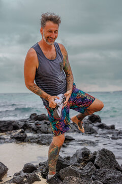 Man laughing while changing on beach