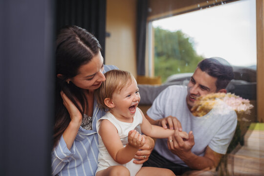 Young woman with husband and baby indoors, weekend away in small cotage n countryside.