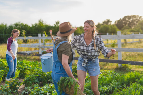 Happy farmers or gardeners working outdoors at community farm.