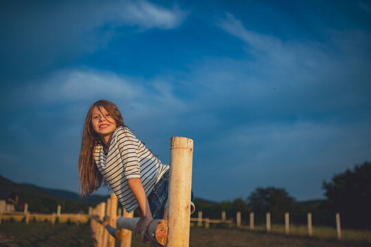Happy girl enjoying summer holidays at grandparents farm.