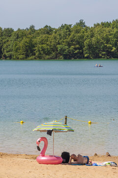 Man relaxing on a sandy beach at Het Blauwe meer lake in Hoogersmilde, Drenthe, Netherlands