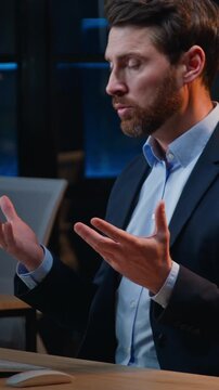 Serious Caucasian business man talking internet virtual video call at night office middle-aged businessman male manager talk conference explaining corporate project consult client overtime at evening