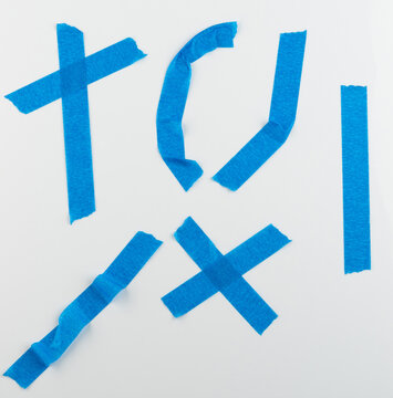 Different shapes made with blue tape on a white background