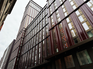 Modern high rise office building facade in Manchester, UK with reflective glass and vertical red panels