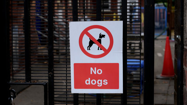 No dogs sign on metal gate, prohibition notice allowed no pets in public park or school entrance
