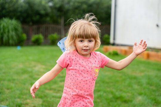 Little Girl Running Outdoors With Windblown Hair During Active Summer Childhood