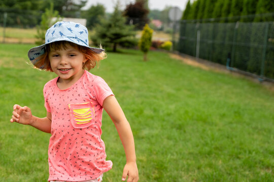 Happy Little Girl Running Across Garden During Summer Outdoor Childhood Adventure