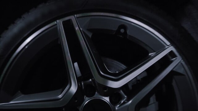 A cinematic shot of a spinning wheel with a forged disc from a sports saloon car. The camera flies between the spokes of the wheel 