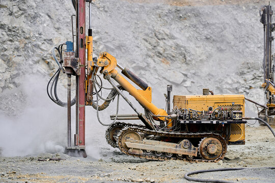 Yellow drilling machine in an open-pit copper mining site