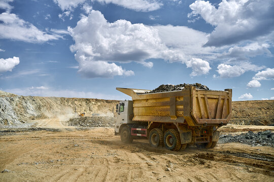 Heavy truck in open-pit copper mining under blue sky