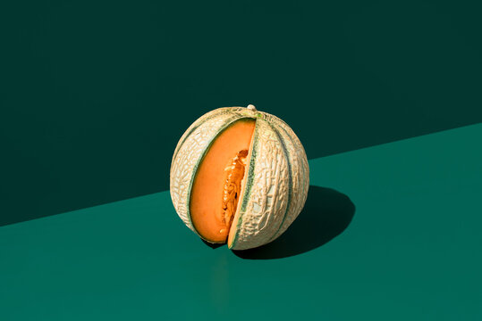 Fresh cantaloupe melon half with seed cavity on green