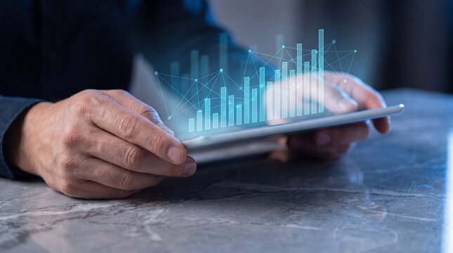 Close-up of hands holding a tablet displaying a holographic bar chart