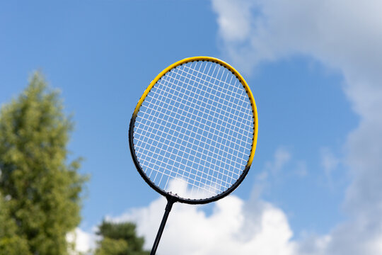 Badminton racket against blue sky with clouds outdoors