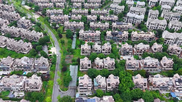 Aerial top-down view of European style villa residential district with winding roads and green trees