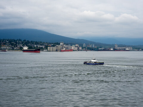 Vancouver BC, Canada - May 30, 2022: SeaBus ferry ship crossing Vancouver harbour on a cloudy day